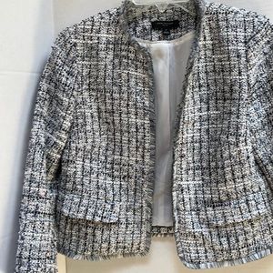 Gray, navy and white tweed jacket with fringe trim.